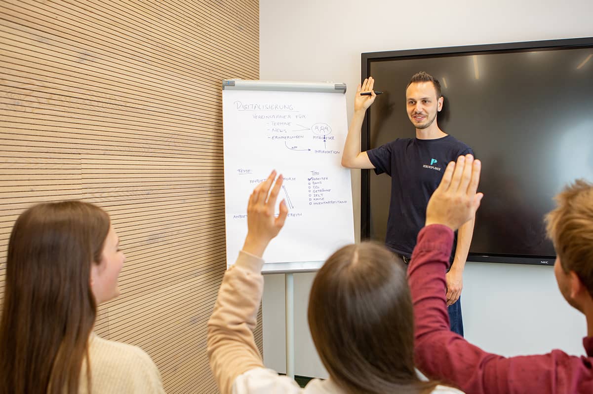 Gruppe stimmt bei der Mitgliederversammlung ab